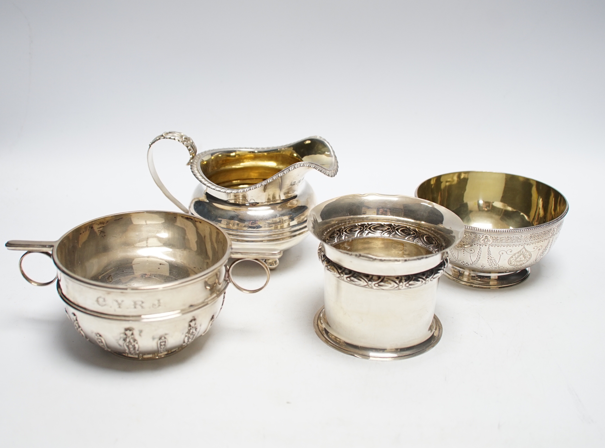 Two silver sugar bowls, London, 1877 and London, 1904, the latter with ring handles, diameter 10.8cm, a silver small vase and a George IV silver cream jug, 21.9oz.